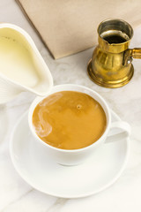 Milk just poured into cup of coffee
