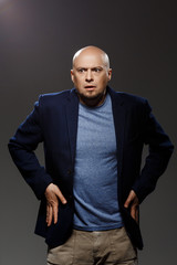 Fototapeta premium Close up portrait of handsome confident middle-aged businessman over black background.