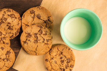 Chocolate chips cookies on baking paper, with milk