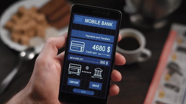 Counter payment via mobile banking application on the smartphone. A man transfers money from his credit card to another person.