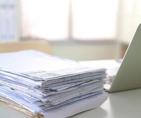 A stack of documentation is on the desktop in the office