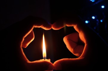 Love symbol around candle light in night