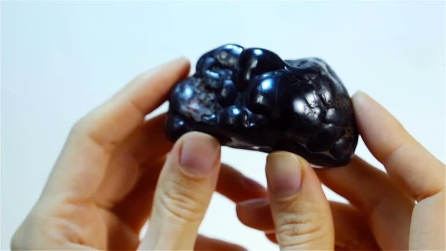 Hematite (haematite) is the black mineral form of iron. Jeweler holding Hematite