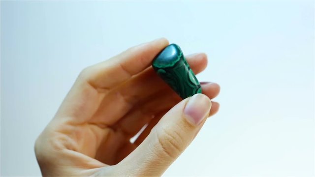 Malachite is a copper carbonate hydroxide mineral. Hand holding green Malachite