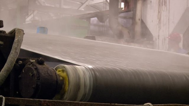 Factory. Papermaking. Sheet of Raw Paper Moving on Conveyer Through Rolls. Steam Raising. Cylinder Turning. Closeup
