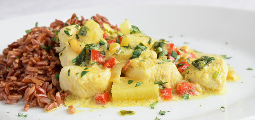 chicken curry with pineapple, pine nuts, cilantro, chili and bell peppers served with red rice