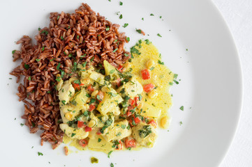 chicken curry with pineapple, pine nuts, cilantro, chili and bell peppers served with red rice