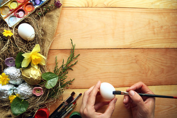 Fototapeta na wymiar A man paints Easter eggs. Easter composition