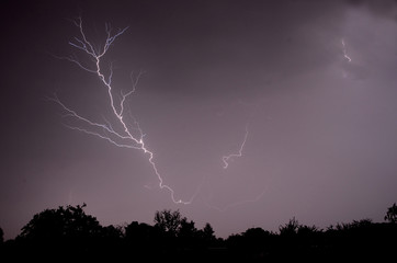 Lighting bolts illuminate the night sky during a night time lighting storm.