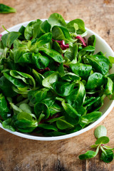 Fresh corn salad in a white bowl on a wooden background