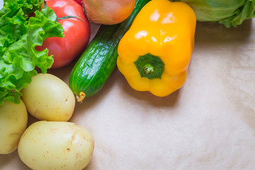 fresh vegetables. Tomatoes, potatoes, cucumber, peppers, onions, lettuce, carrots, cabbage on a table with paper