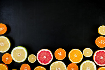 Lemon, orange, mandarin, grapefruit and sweetie on black background. Flat lay, top view. Fruit background
