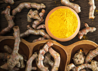 Turmeric roots on wooden background