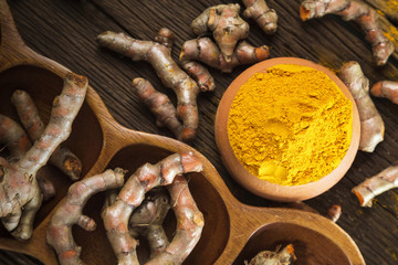Turmeric roots on wooden background