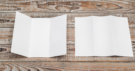 Trifold white template paper on wood texture .