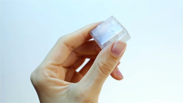 Fluorite (fluorspar) is a fluorescent mineral. Jeweler holding Fluorite