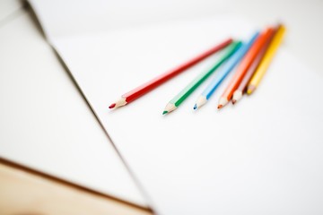Multicolored pencils lying on a white table