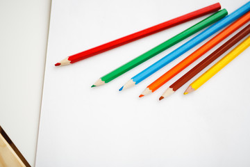 Multicolored pencils lying on a white table
