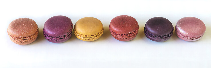 rank of traditional multicolored macaroons on white background