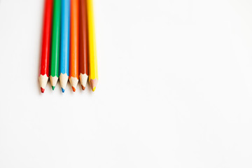 Multicolored pencils lying on a white table