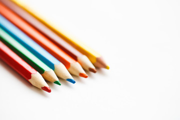 Multicolored pencils lying on a white table