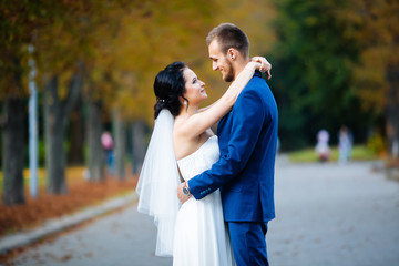 The couple gently hugging in the autumn park