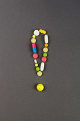 Exclamation point created from colored pills. Medical concept