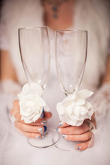 The bride is holding two wedding glass. Close-up. Wedding decor.