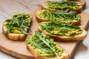 Healthy green food. Vegan sandwiches with avocado on wooden background
