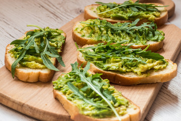 Healthy green food. Vegan sandwiches with avocado on wooden background
