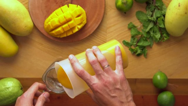 Man puts a mango smoothie in a glass. Mango shake. Healthy life concept