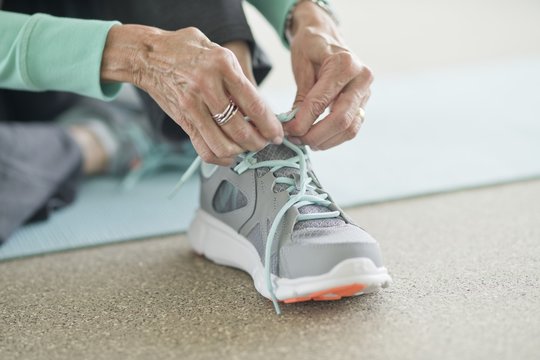 Close-up Of Woman Tying Up Sneakers