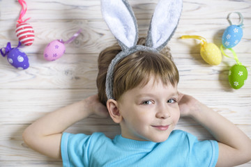 Fototapeta na wymiar Easter concept. Happy cute child wearing bunny ears getting ready for Easter