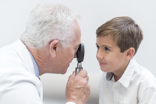 Male optician testing boy's eyesight