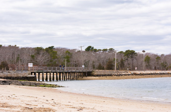 Fishermen crossing wooden bridge to catch shell fish