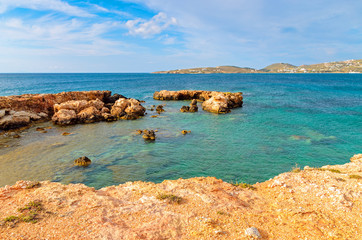 Rocky coast and crystal sea water in Parikia bay on Paros island, Greece.