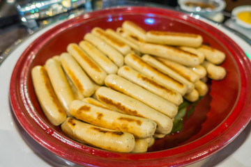Grilled chicken sausages on plate .