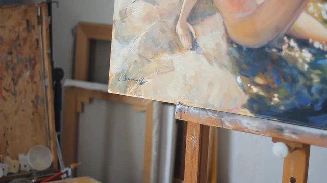 panoramic shot of the picture painted with oil paint. close-up. a picture of a woman sitting on the stones. Large mask. the style of painting realism. a big canvas to paint on the easel.