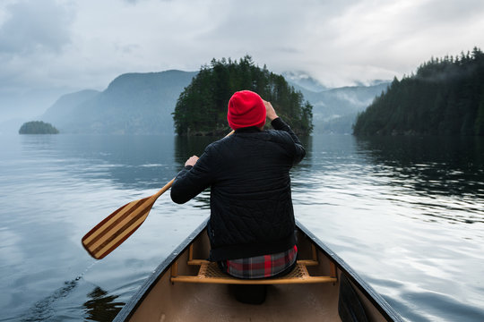 Canoeist rowing canoe in lake
