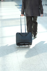 A man with a suitcase on wheels at the airport