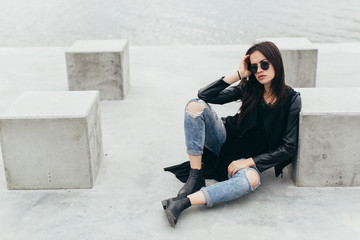 Stylish model in sunglasses posing at the urban lake.