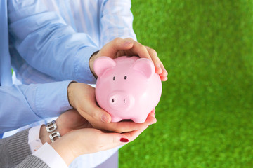 A man and a woman keep a piggy bank carefully
