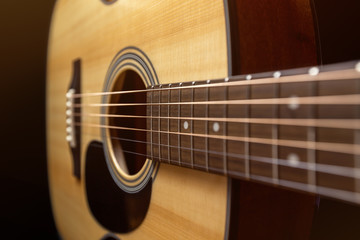 Obraz na płótnie Canvas Yellow acoustic wooden guitar on a black background
