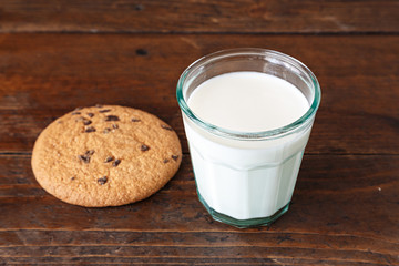 glass of milk with biscuits on wooden table