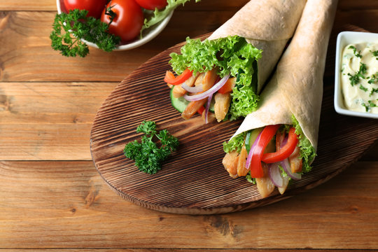 Tasty kebab sandwiches on wooden board