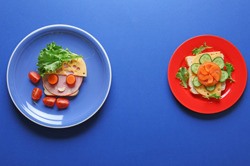 Plates with funny sandwiches on blue background