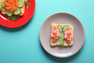 Plates with creative sandwiches on color background