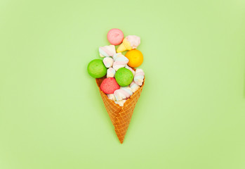 photo of colorful marshmallows and waffle cone on the wonderful green background