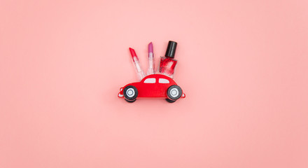 photo of lipsticks, nail polish and car shaped toy on the wonderful pink studio background