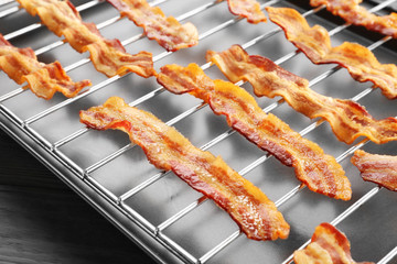 Baking tray with strips of fried bacon, closeup